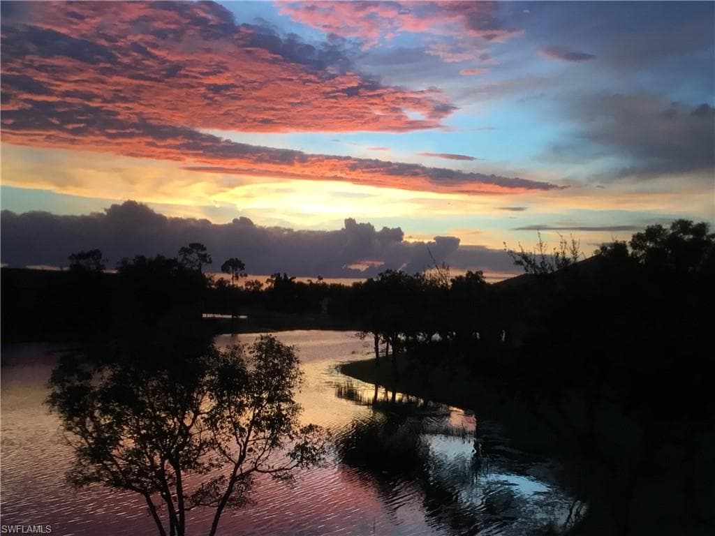 Sunsets over lake with fountain view.