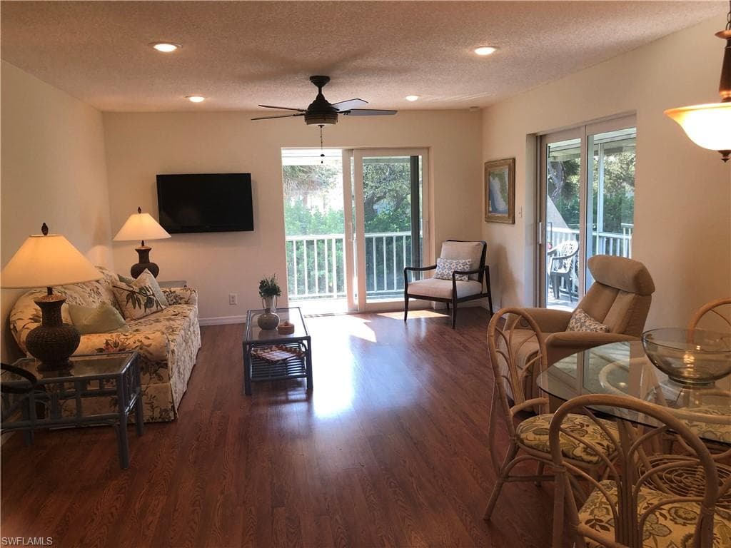 two sliding glass doors in living room going out to L-shaped lanai