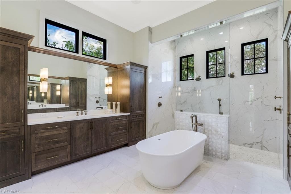 Master bathroom with large his and her vanities opposite one another, soaking tub, and extra large, dual head walk-in shower