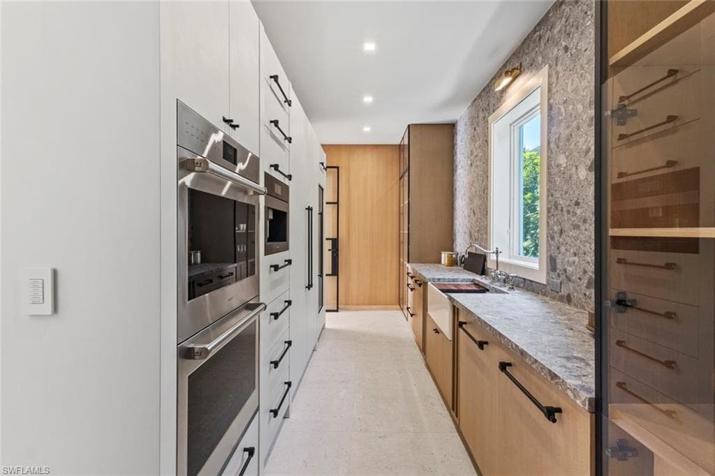 Kitchen with stainless steel double oven, white cabinetry, modern cabinets, and recessed lighting