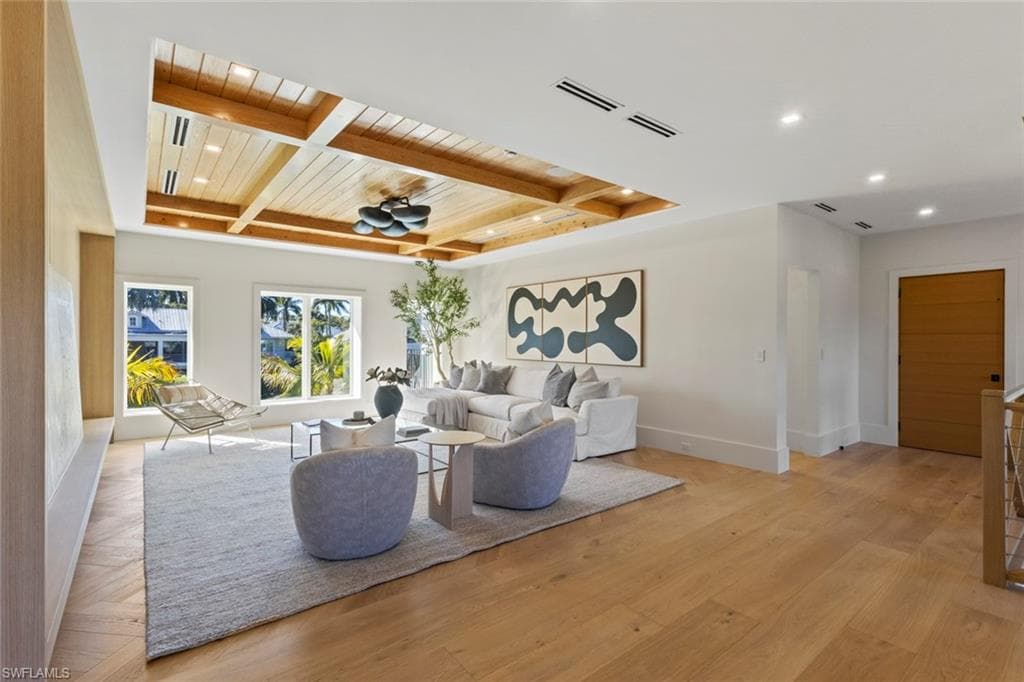 Living room featuring a wooden ceiling with exposed beams, light wood finished floors, coffered ceiling, and recessed lighting