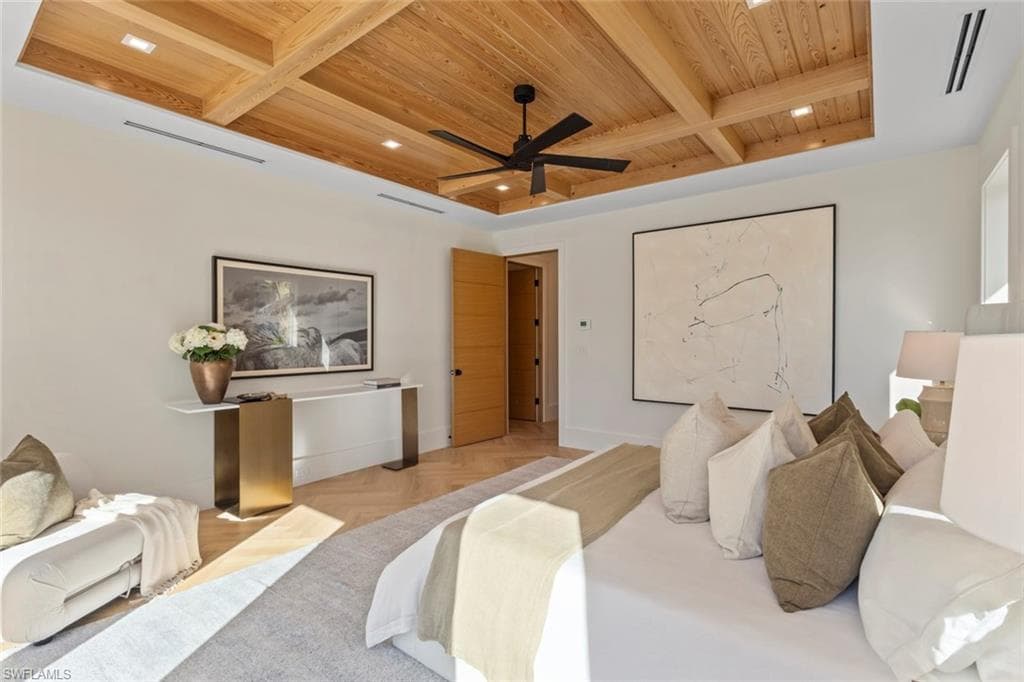 Bedroom with a wooden ceiling with exposed beams, ceiling fan, and coffered ceiling