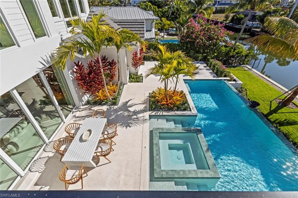 View of swimming pool featuring a pool with connected hot tub and a patio