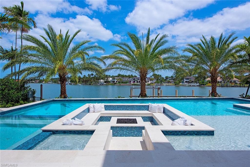 Pool featuring a patio, an in ground hot tub, and a water view