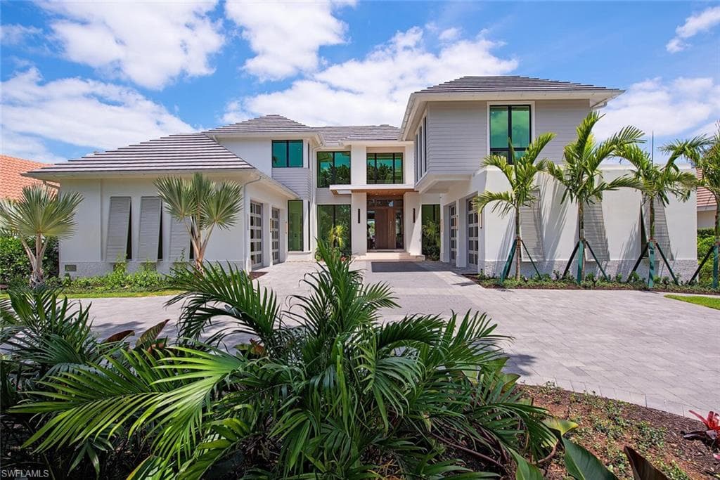 View of front of home with driveway and stucco siding