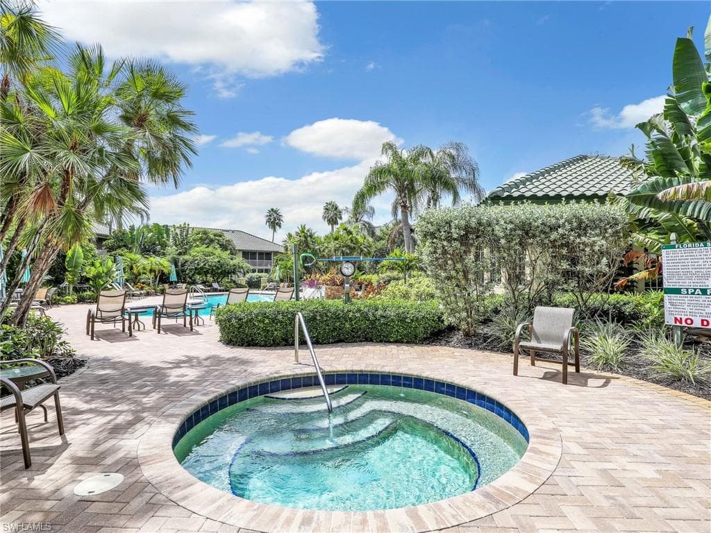 View of Palm Colony pool featuring a community hot tub and a patio