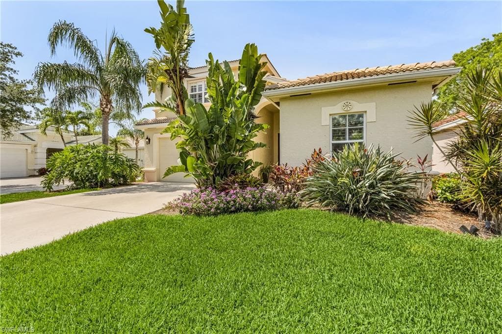 Mediterranean / spanish-style house with a front lawn and a garage