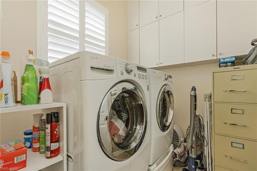 Laundry area featuring washer and dryer and cabinets
