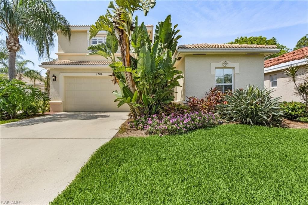 Mediterranean / spanish home with a garage and a front yard