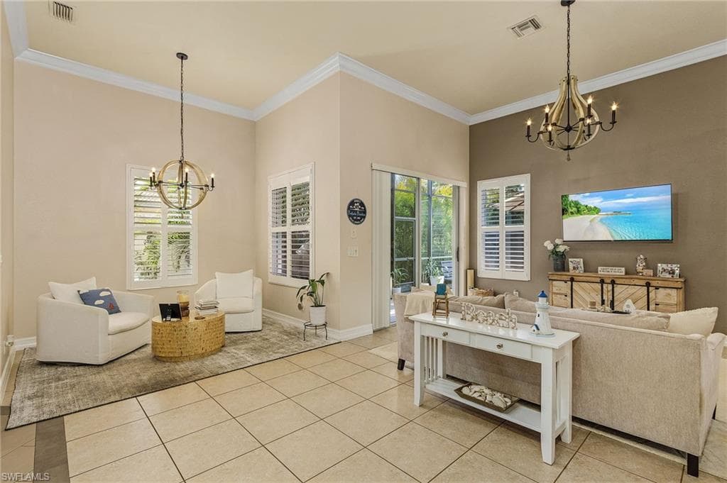 Tiled living room featuring an inviting chandelier and crown molding