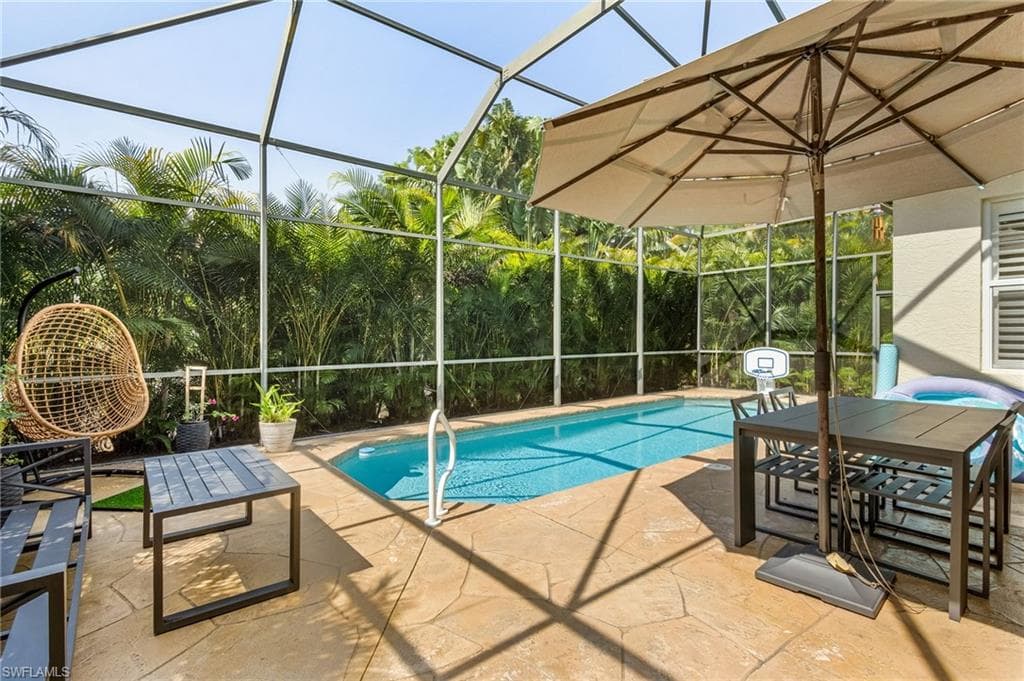 View of pool with a lanai and a patio area