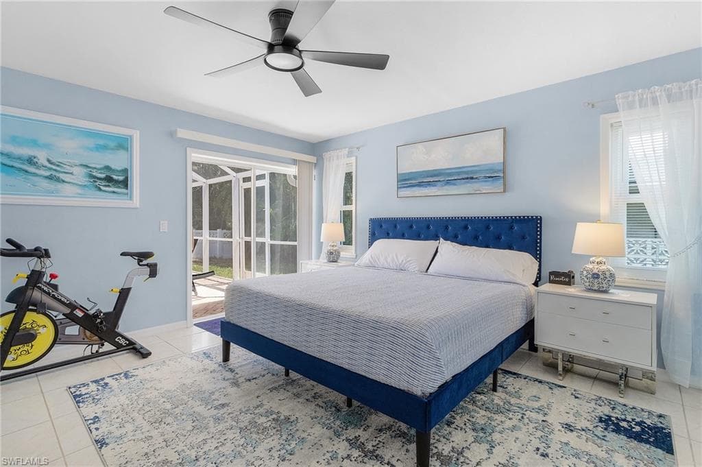 Tiled bedroom with ceiling fan and multiple windows