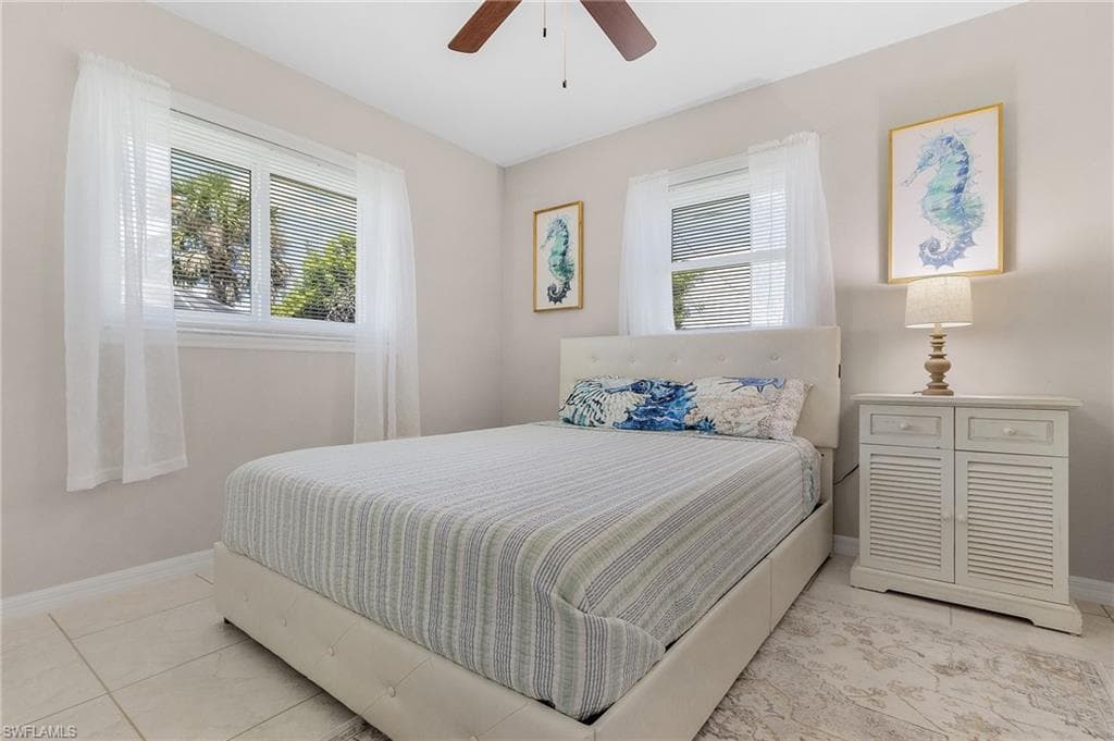 Tiled bedroom featuring ceiling fan