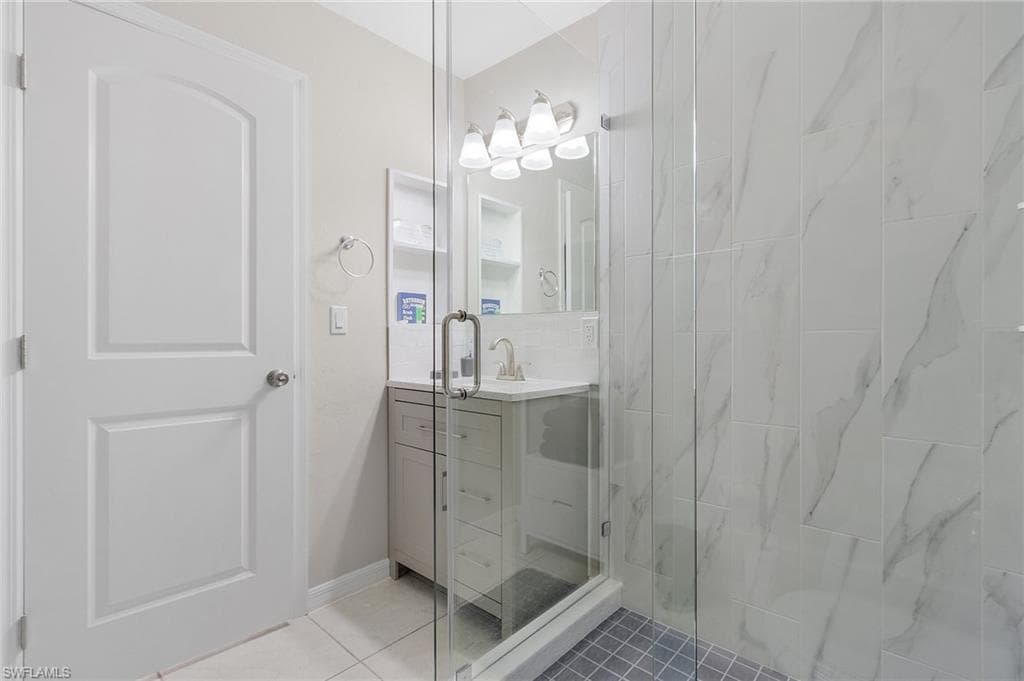 Bathroom with an enclosed shower, tile floors, and large vanity