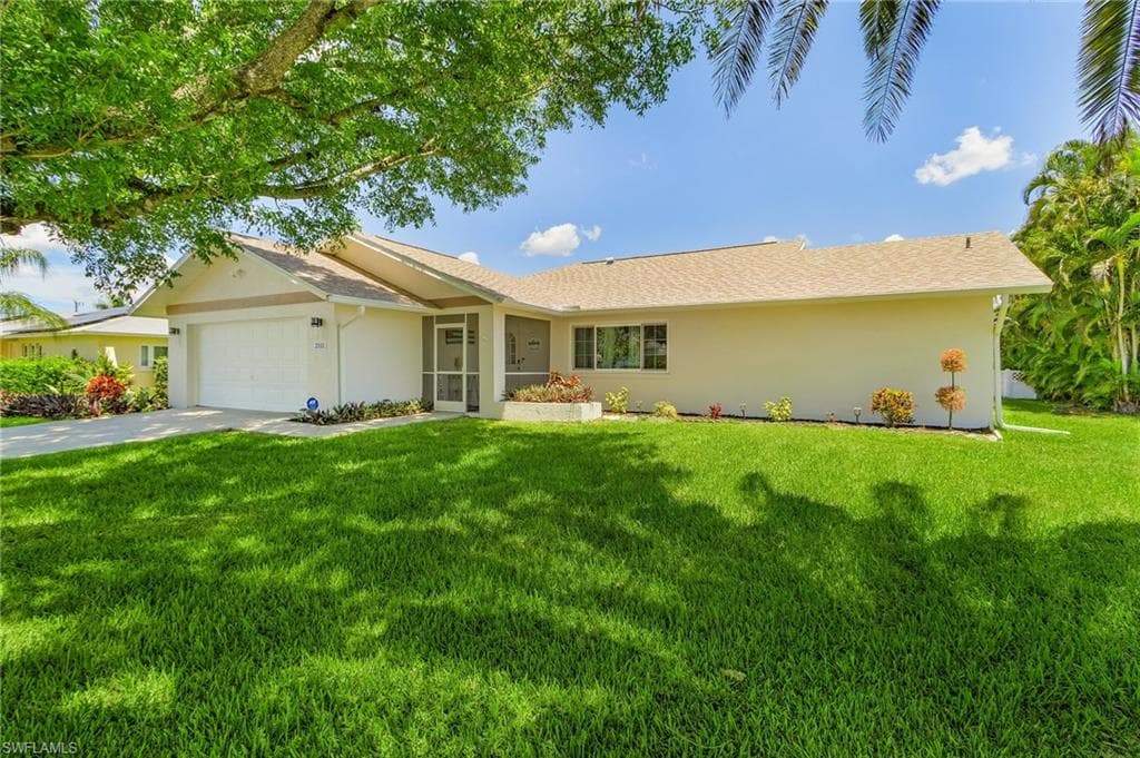 Single story home featuring a front yard and a garage