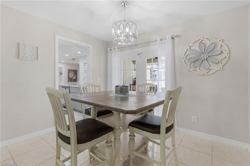 Tiled dining room with a chandelier