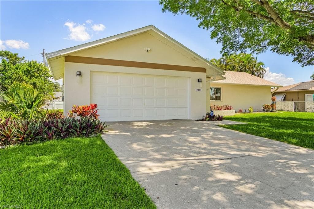 Single story home with a front yard and a garage