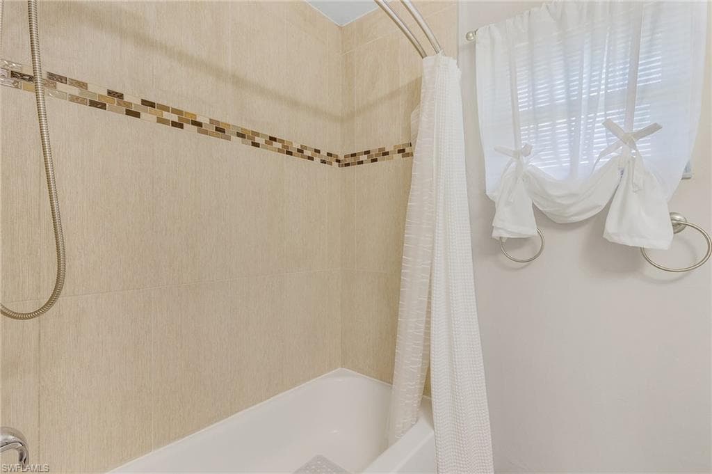 Bathroom with shower / bath combination with curtain