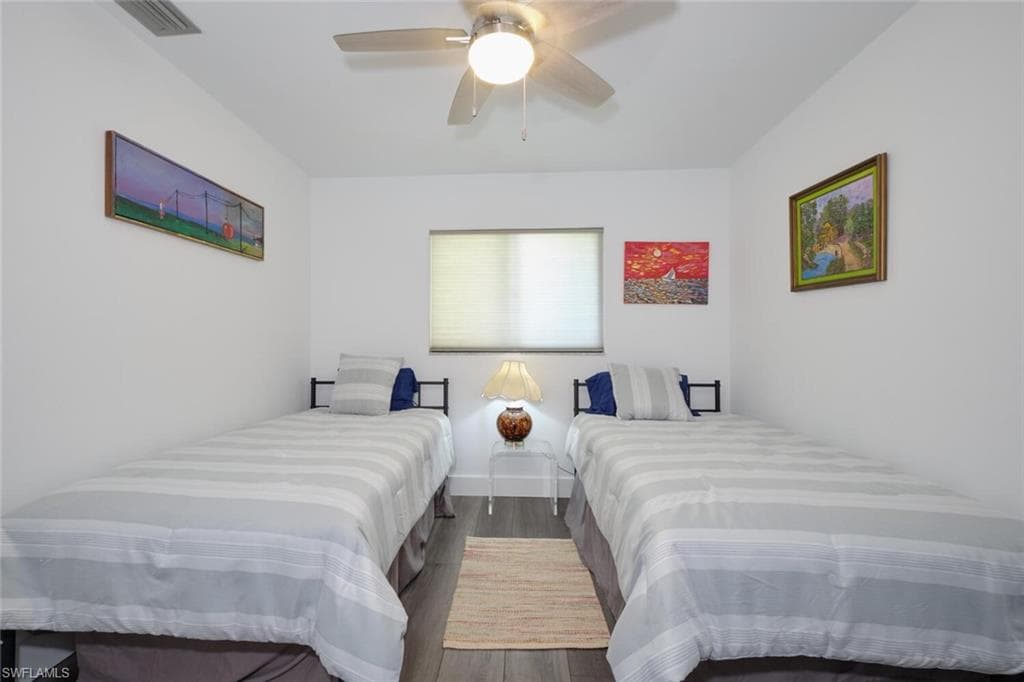 Bedroom with hardwood / wood-style floors and ceiling fan