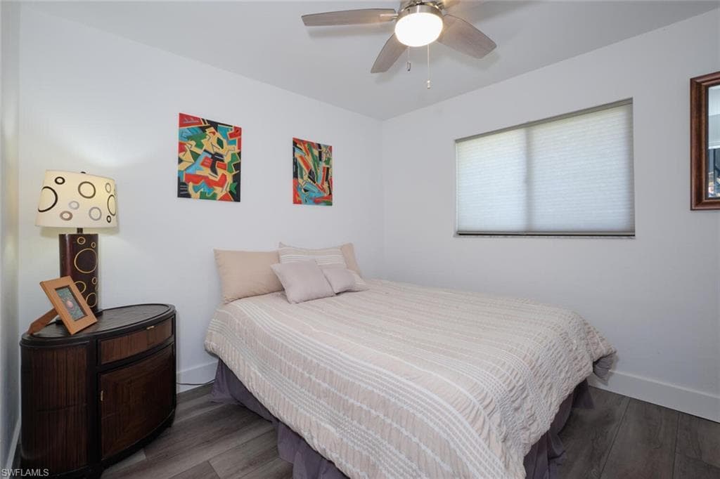 Bedroom with ceiling fan and dark wood-type flooring