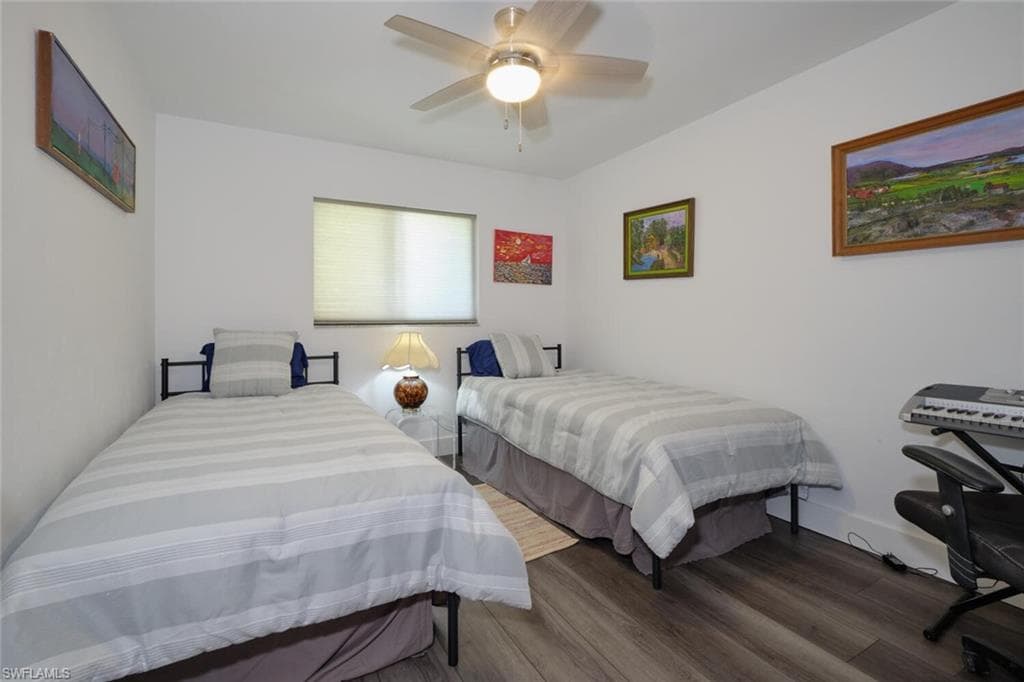 Bedroom featuring dark hardwood / wood-style floors and ceiling fan