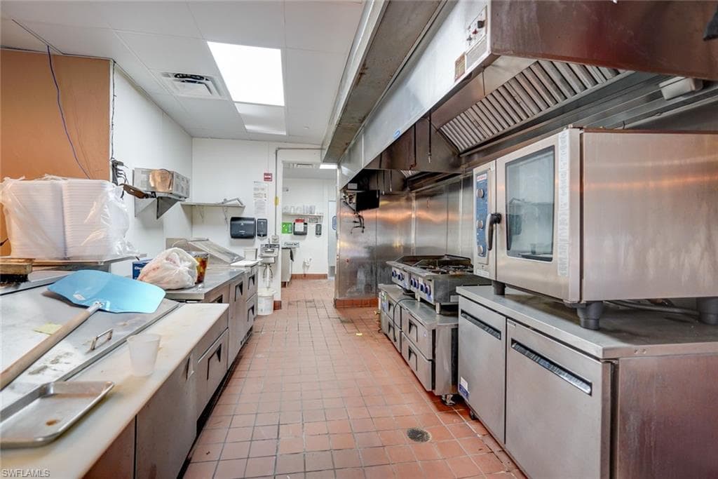 Kitchen with stainless steel counters and light tile floors