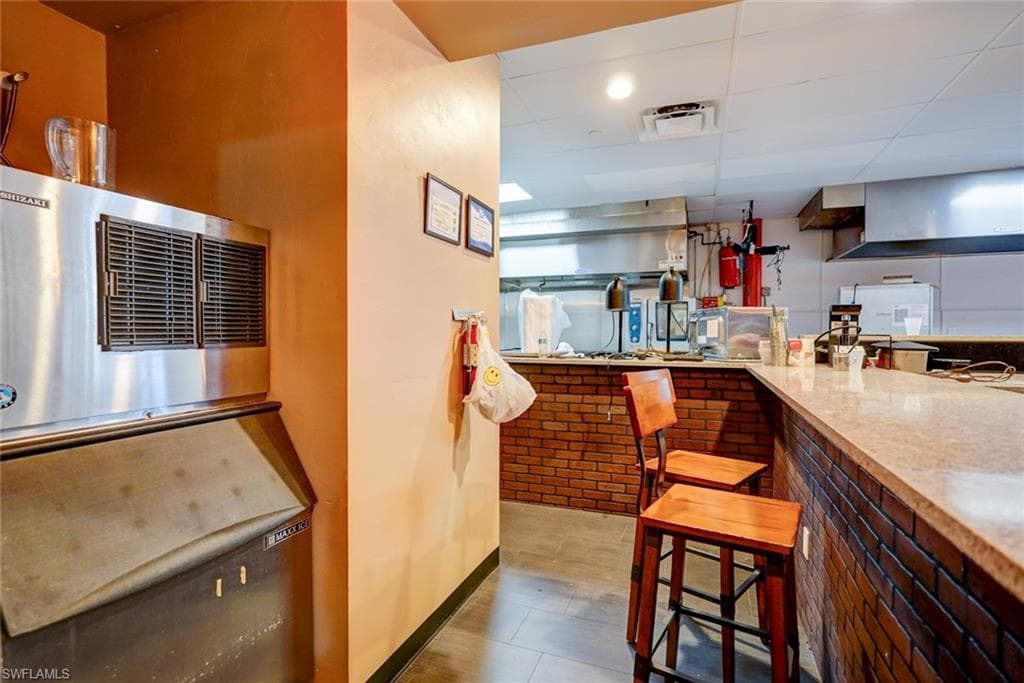 Kitchen with tile flooring and light stone counters