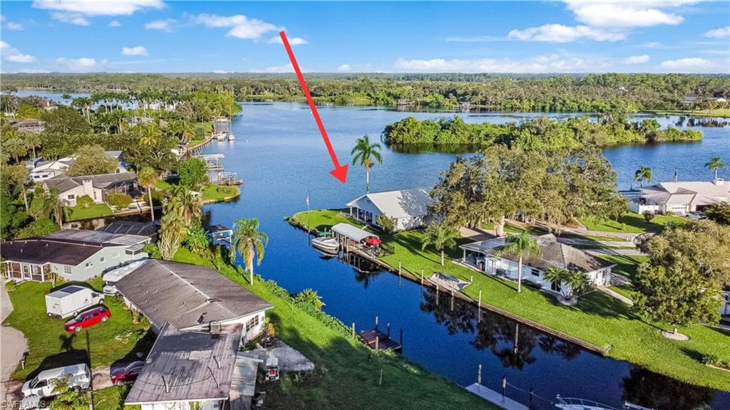 Aerial view of home on the river and wide canal at side of home. Oversized 1/3 acres lot and end of cul-de-sac.