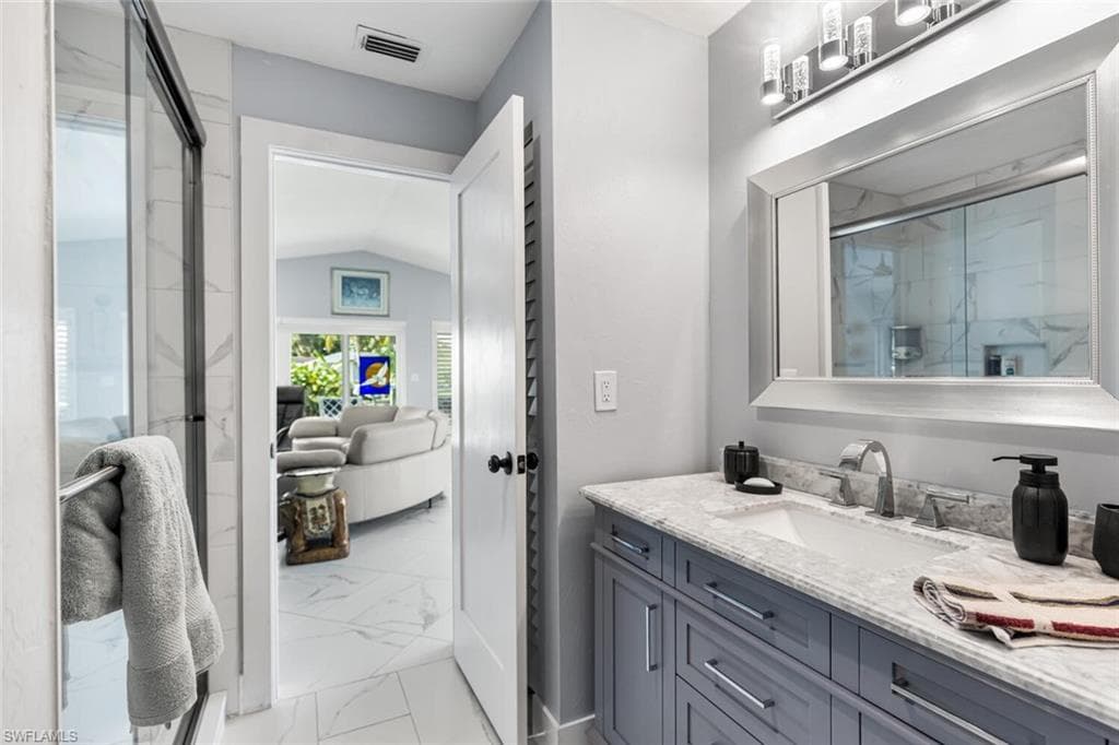 Guest bath is adjacent to Guest Bedroom just off of Living Room. Quartz counter top vanity and shower.