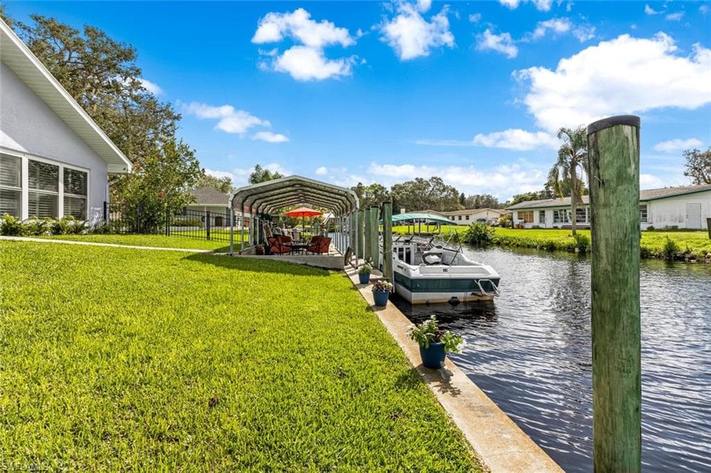View of dock and seawall along with covered dock landing area. Also fence is in view. Great for letting your pets have room to play.