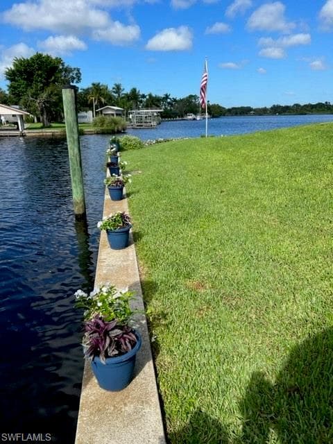 Dock area featuring a water view and a yard