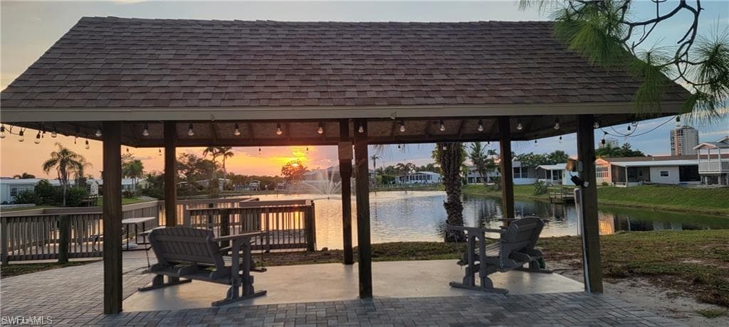 Lake at dusk with a water view and a gazebo