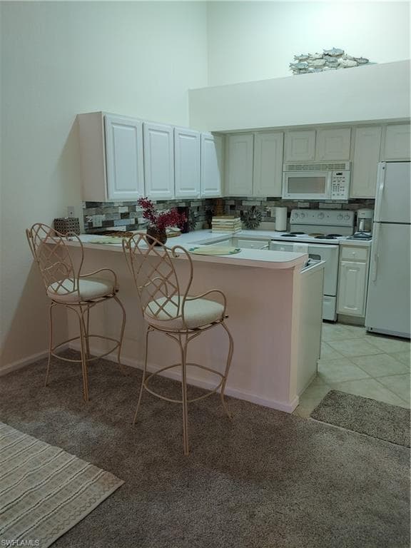 Kitchen with kitchen peninsula, range, and refrigerator