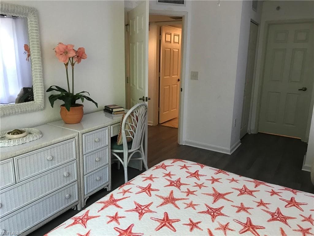 Bedroom with dark hardwood / wood-style floors