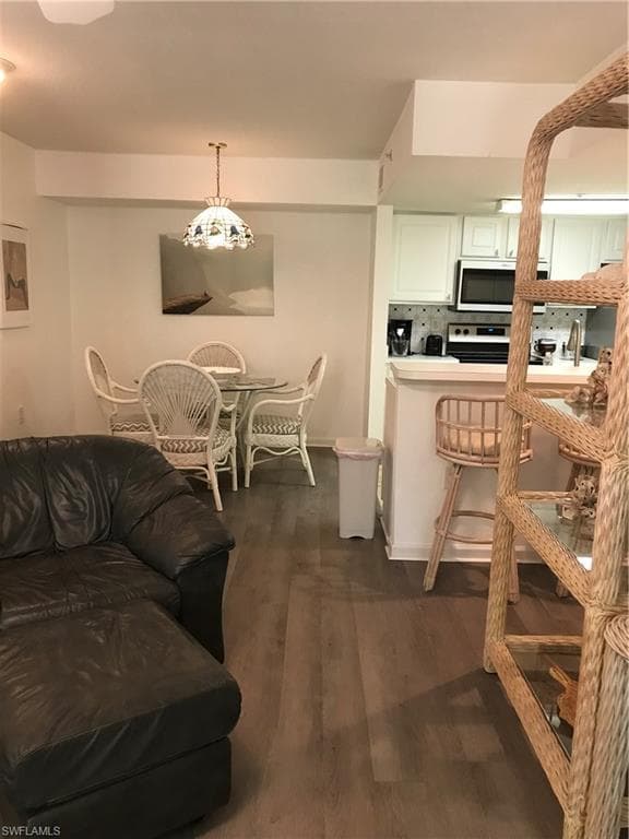 Living room featuring a notable chandelier and dark wood-type flooring