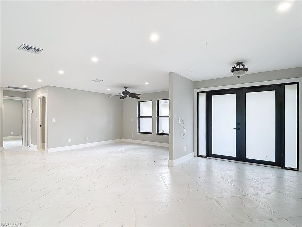 Unfurnished room featuring french doors, light tile flooring, and ceiling fan