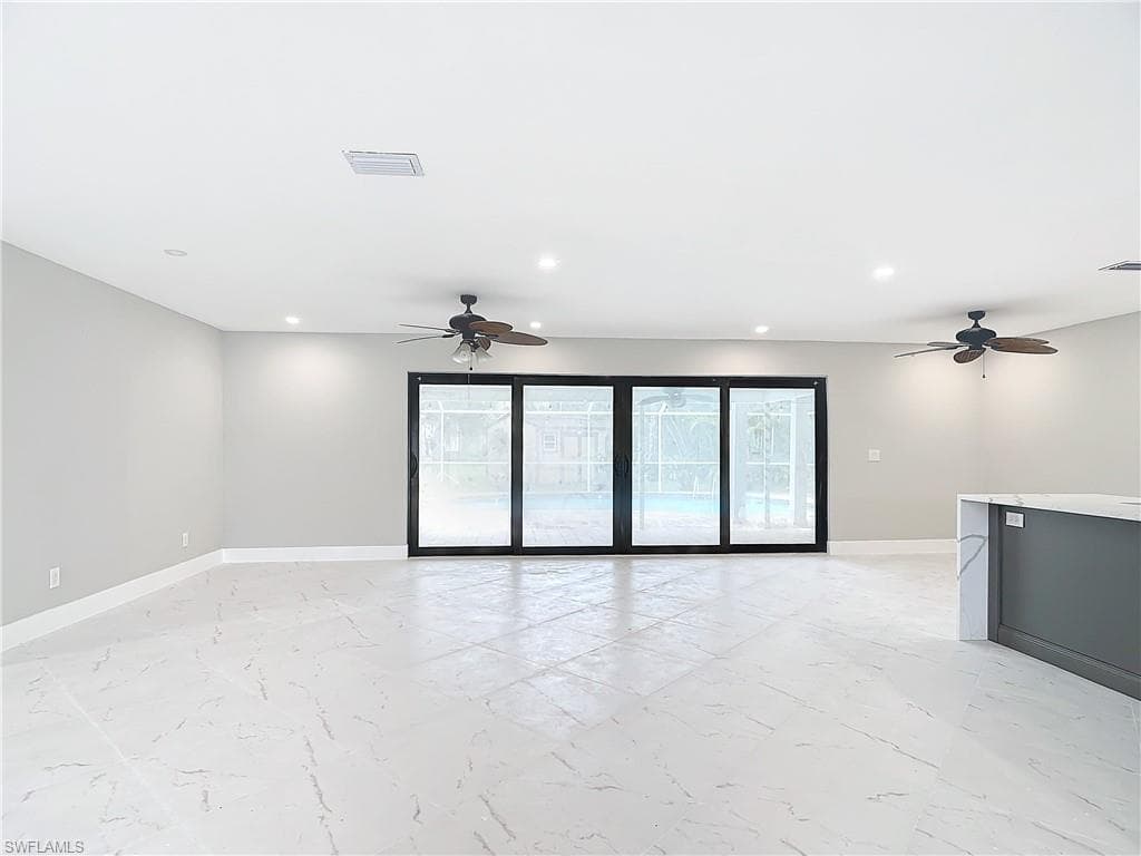 Tiled empty room featuring ceiling fan