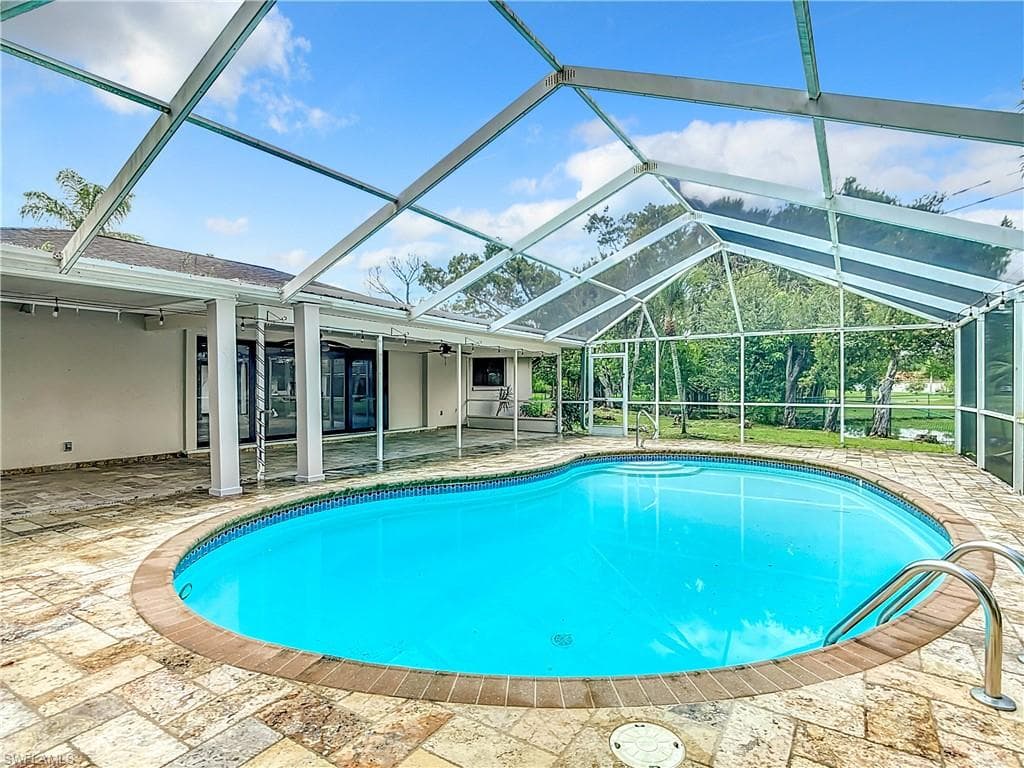 View of pool with a patio area and a lanai