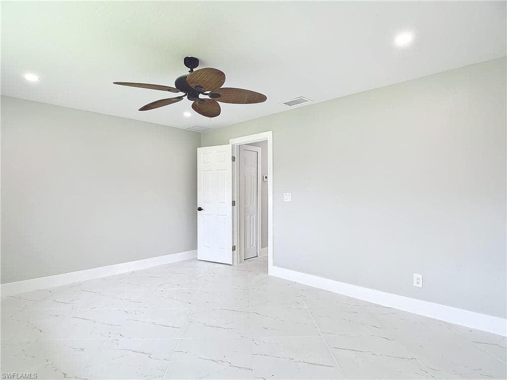 Empty room featuring ceiling fan and light tile floors