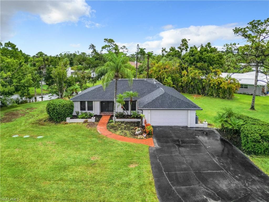 Single story home with a garage and a front yard