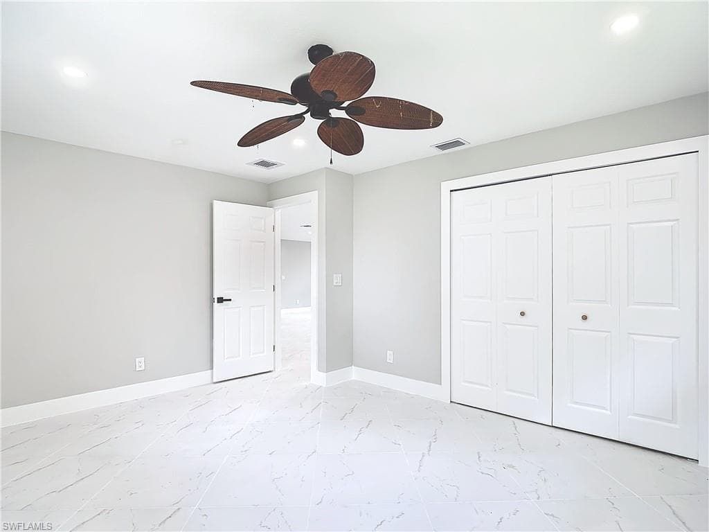 Unfurnished bedroom featuring a closet, ceiling fan, and light tile floors