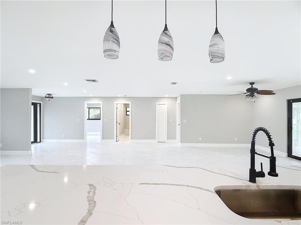 Living room featuring a wealth of natural light, sink, and ceiling fan