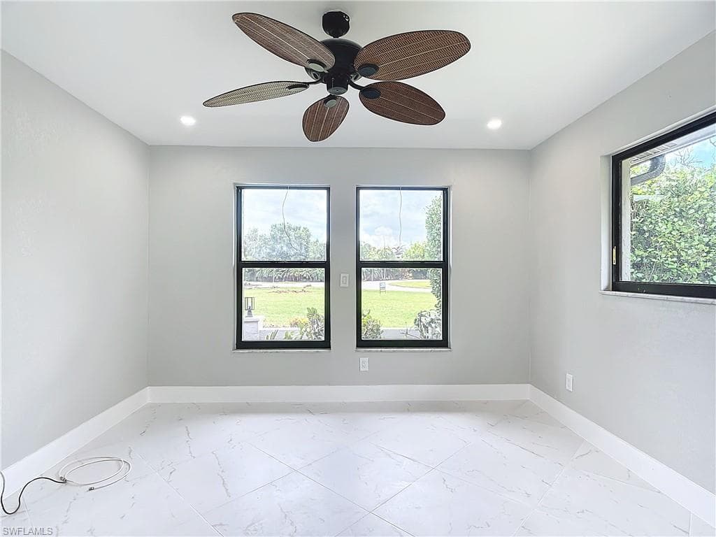 Unfurnished room featuring a healthy amount of sunlight, light tile flooring, and ceiling fan