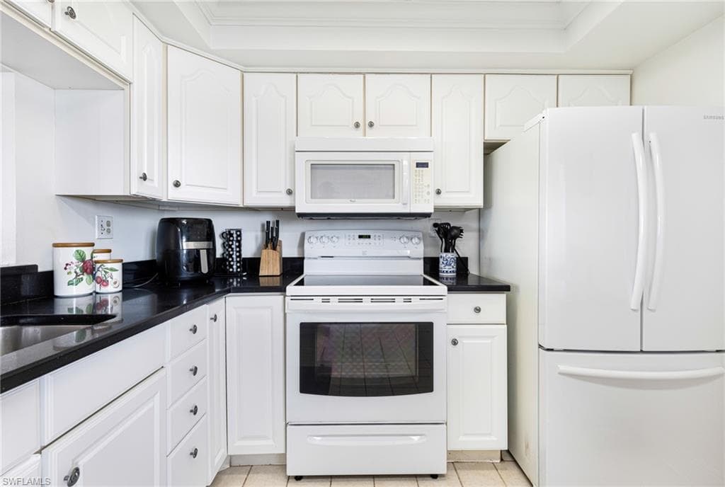 Kitchen featuring white cabinets, white appliances, and crown molding