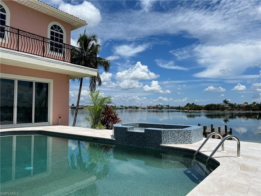 View of pool featuring an in ground hot tub and a lake view
