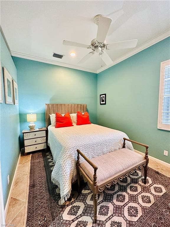 Tiled bedroom with ceiling fan and crown molding