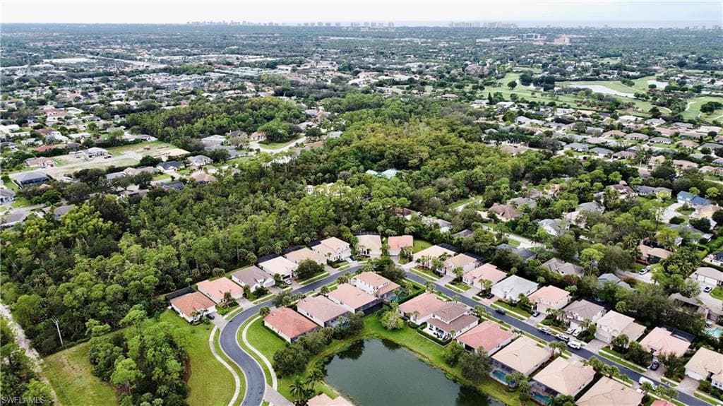 Birds eye view of property with a water view