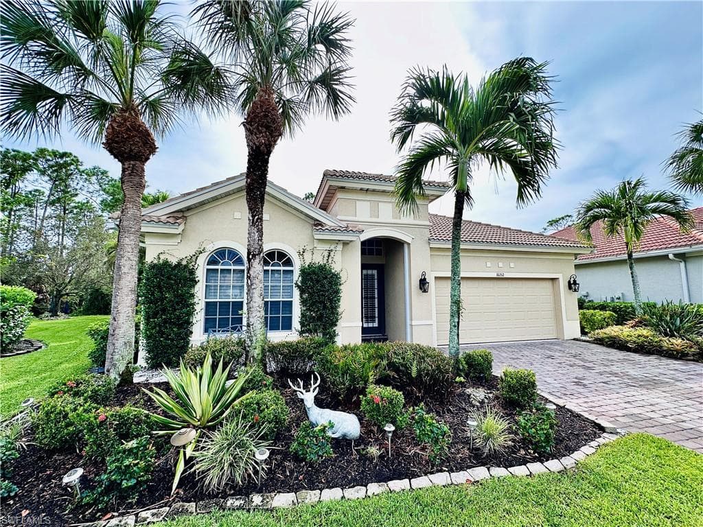 View of front of house with a garage and a front yard