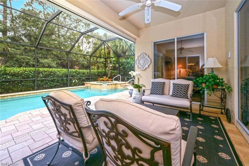 View of pool featuring an in ground hot tub, a patio, ceiling fan, and a lanai