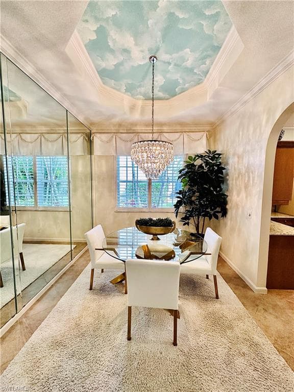 Sitting room featuring a healthy amount of sunlight, a raised ceiling, and a chandelier